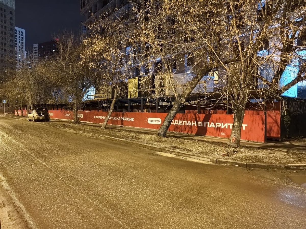 Протяжённое ограждение ЖК «Тёплые кварталы» с крупной надписью «Сделан в Паритет» и адресом сайта застройщика